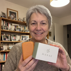 Une cliente de 63 ans tient le savon Hanaé et sa boîte chez elle